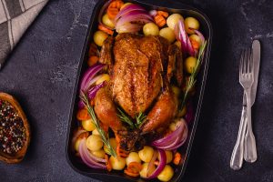 Whole baked chicken with vegetables.